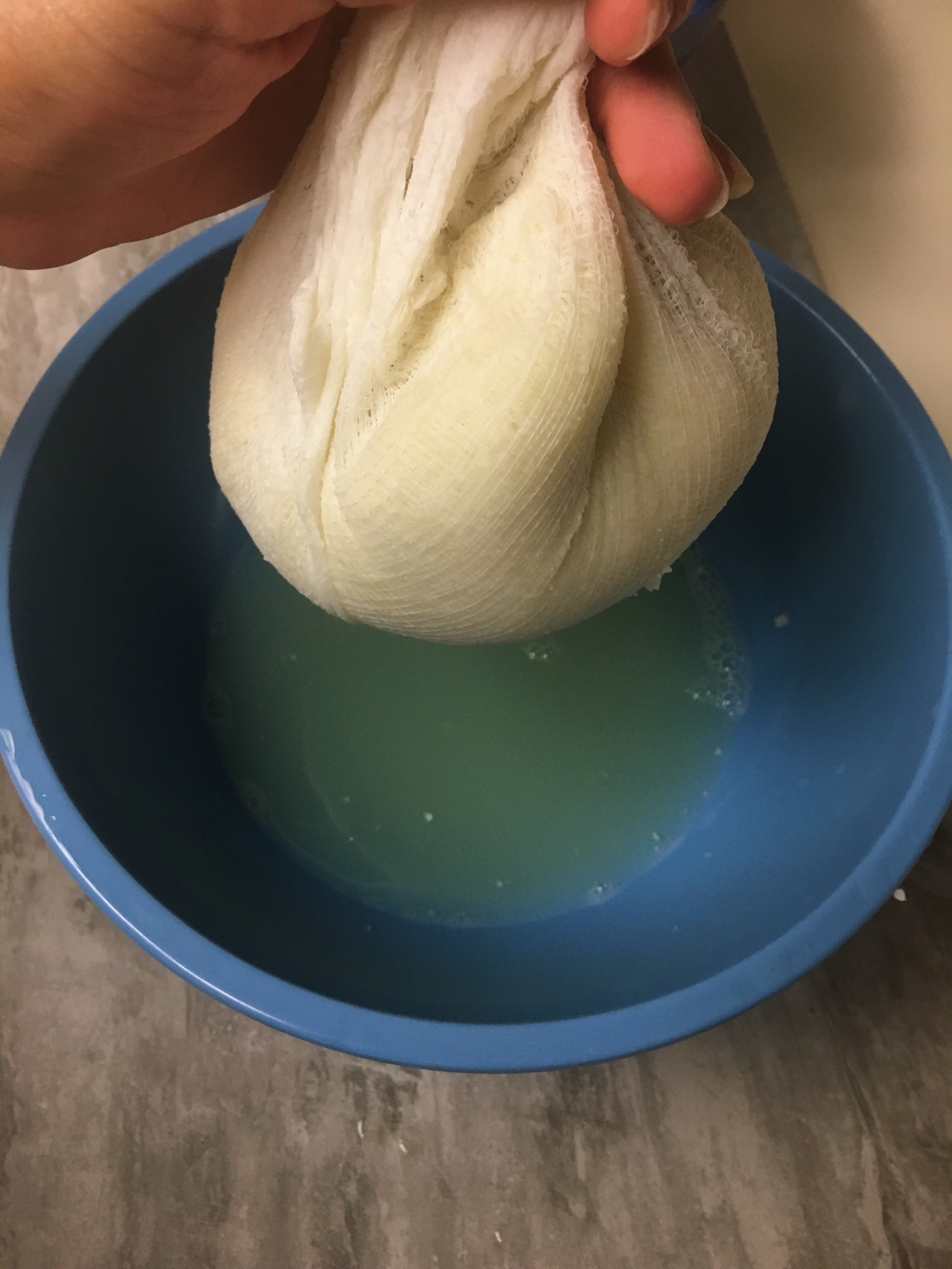 cauliflower being drained by a cheese cloth for the making of a delicious no carb pizza crust