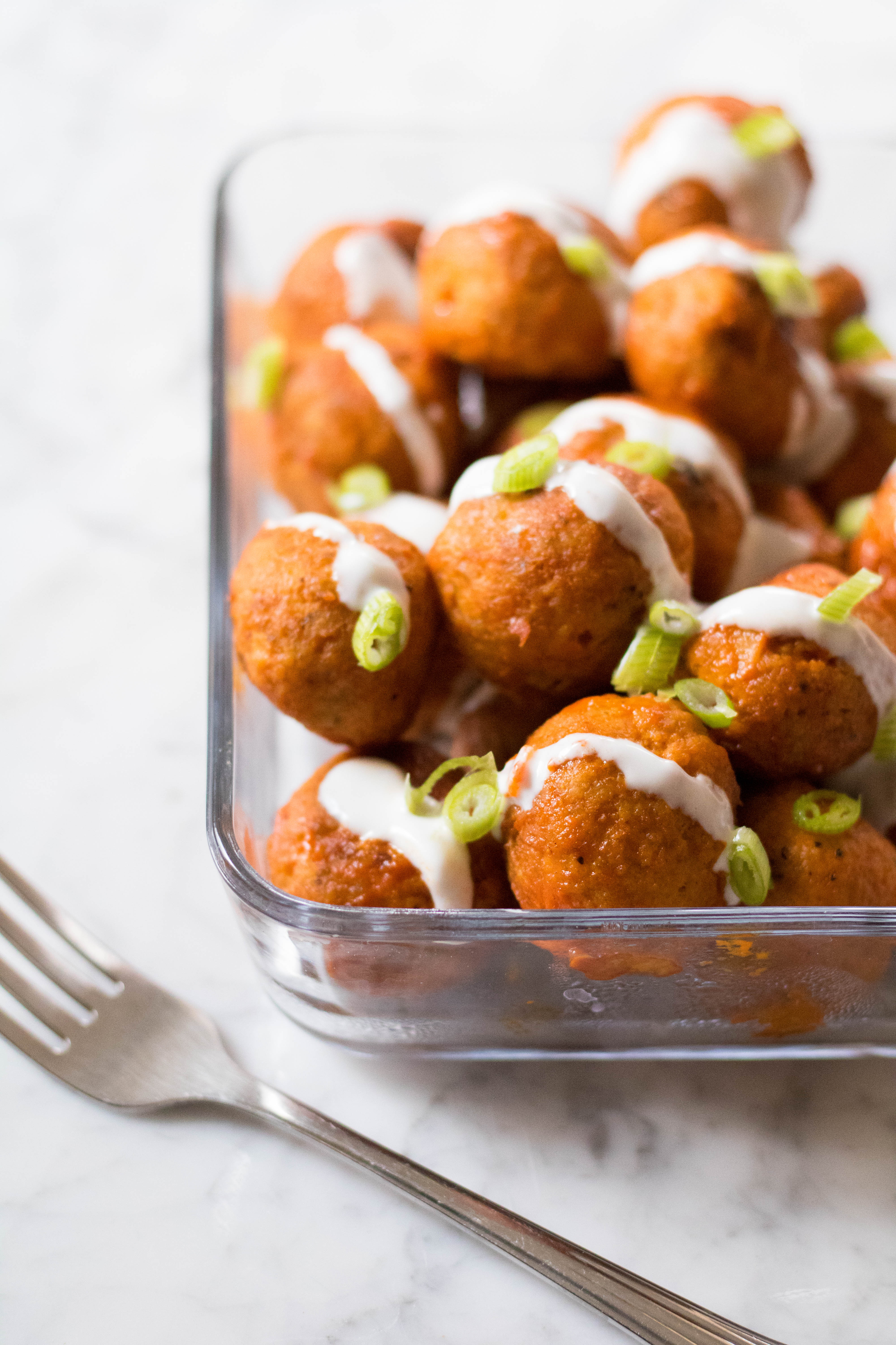 Container of healthy baked buffalo chicken meatballs.