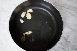 sautéing garlic to infuse the olive oil with flavor for the marinara sauce