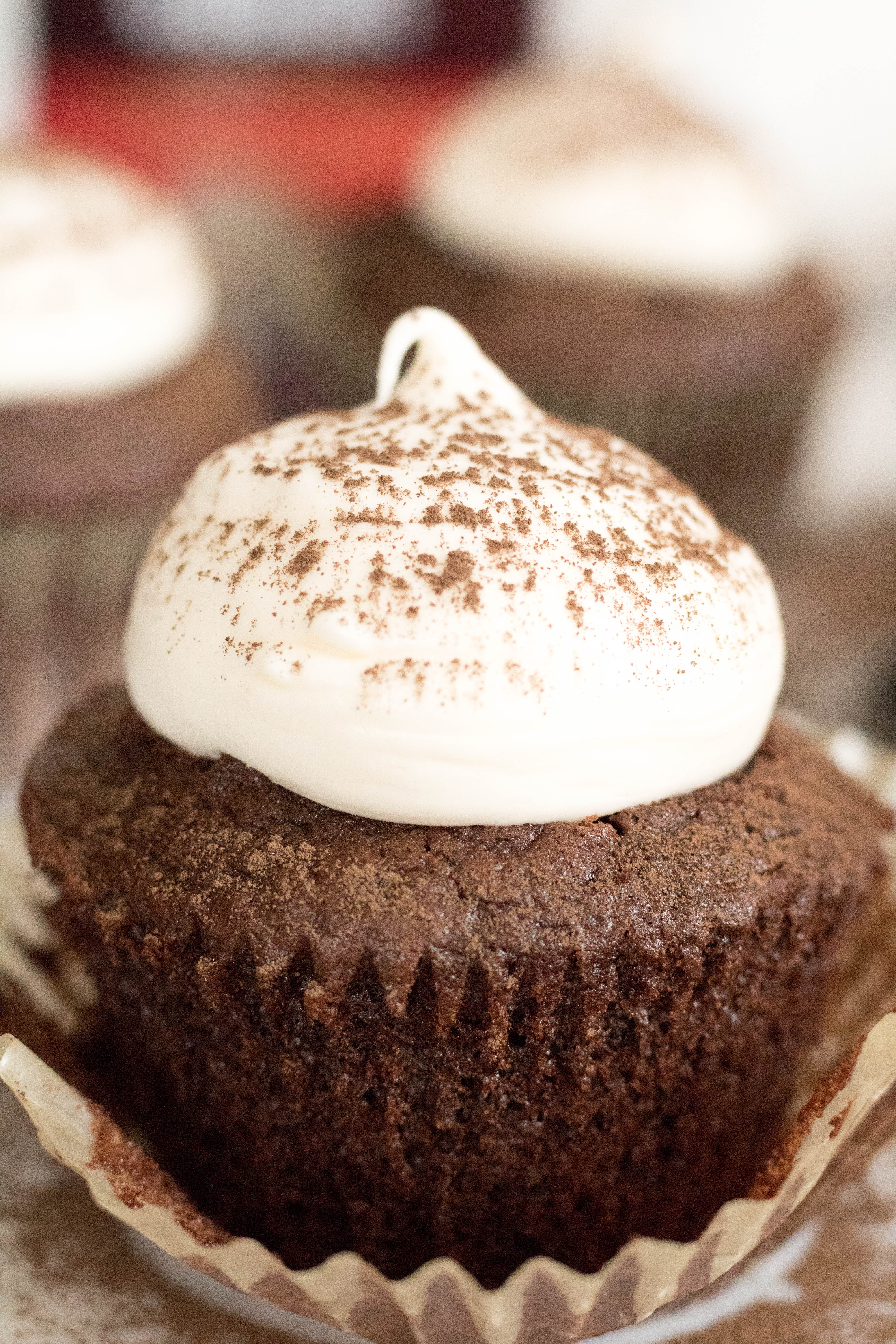 Chocolate cupcake with a dollop of cream cheese frosting and a light dusting of hershey's cocoa! 