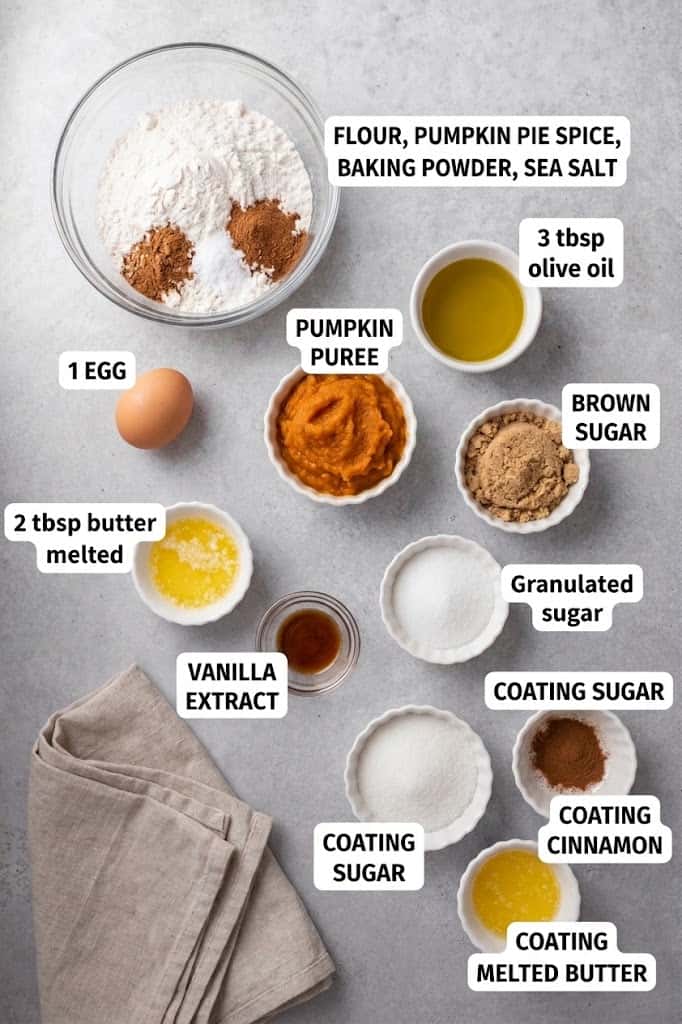 Flour, pumpkin puree, brown sugar, eggs, butter and spices measured out for pumpkin donuts.