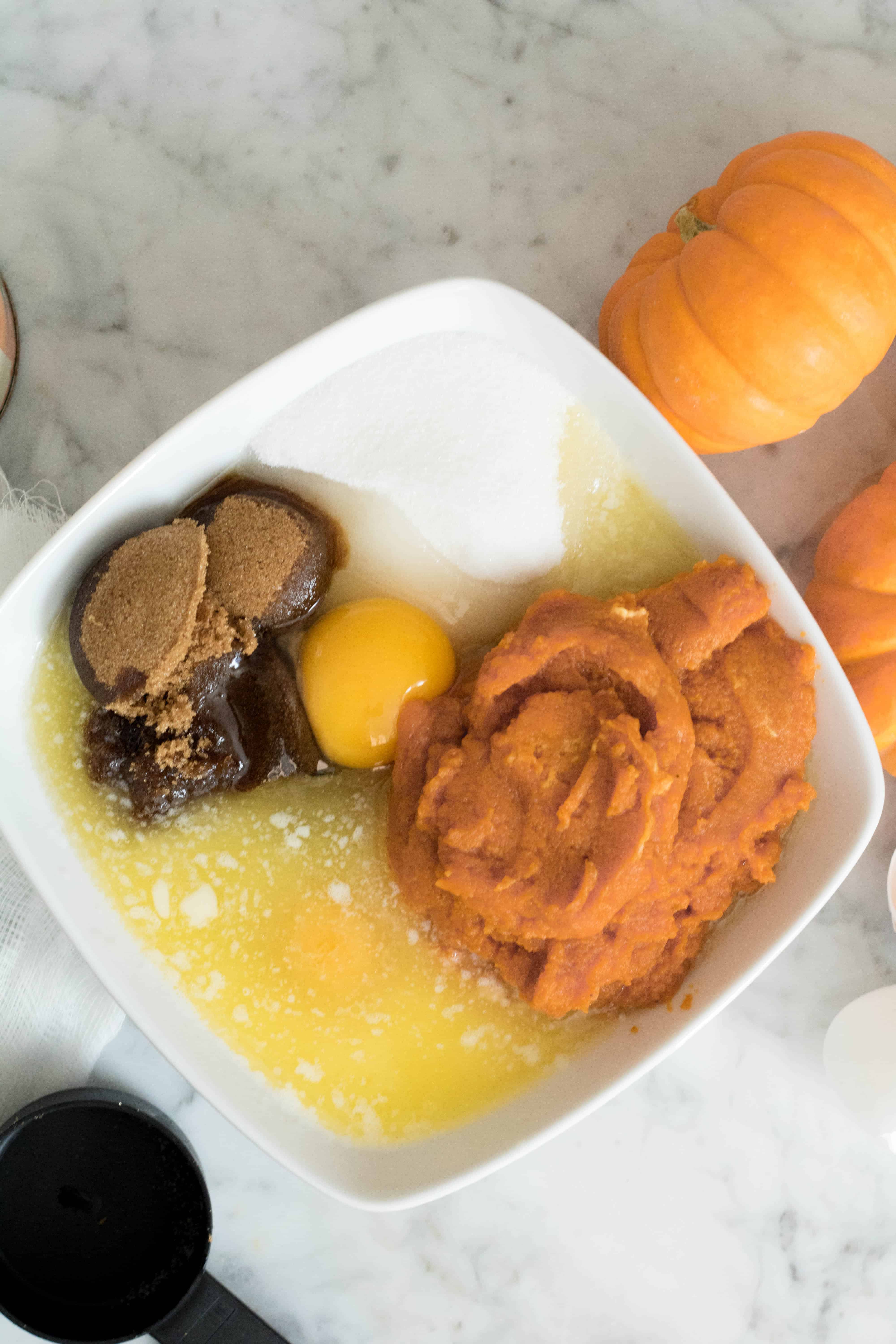 Eggs, pumpkin puree, brown sugar, regular sugar, and butter before mixing them to make the muffin batter