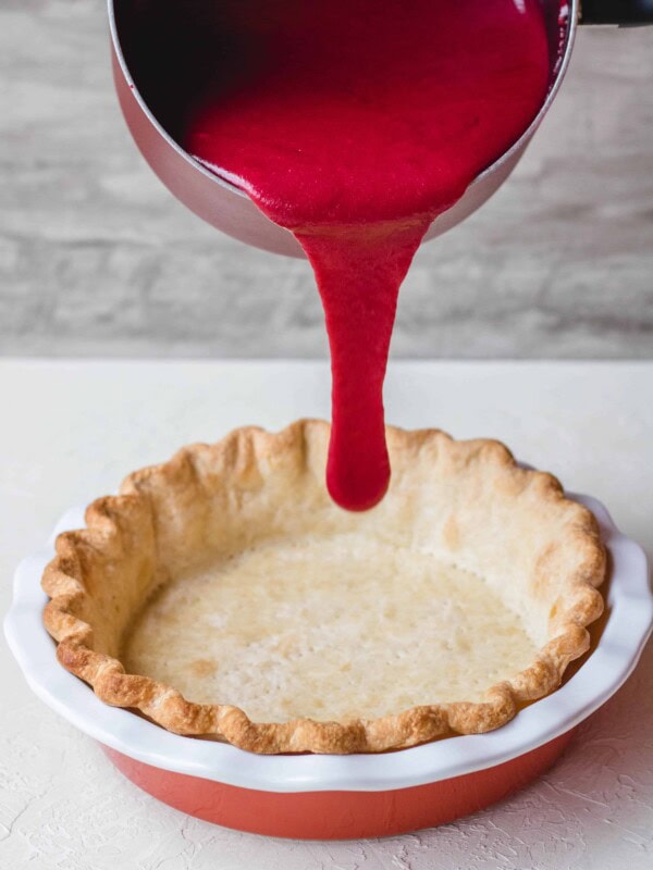 Pie crust filled with cranberry custard before baking