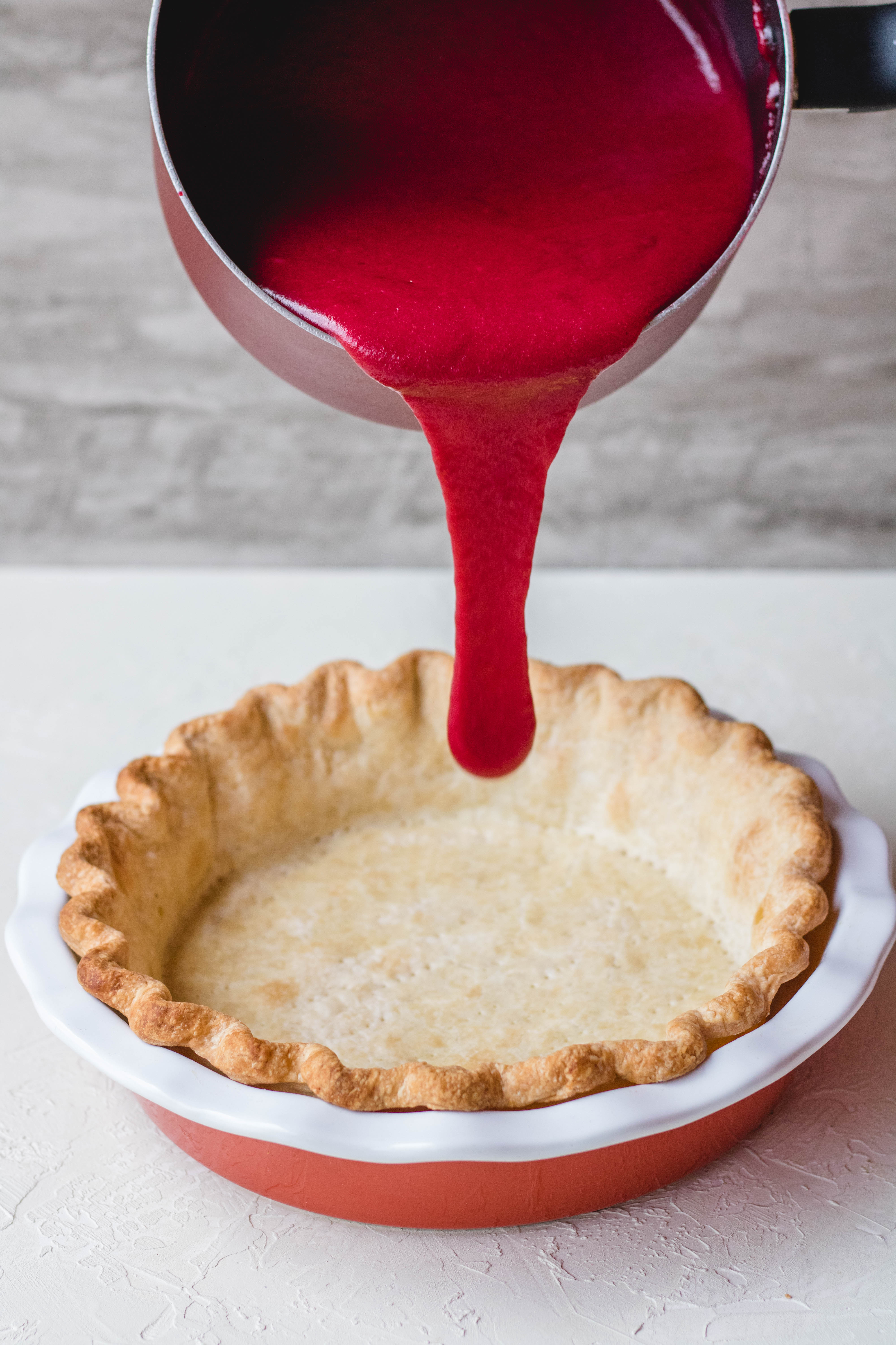Pie crust filled with cranberry custard before baking 