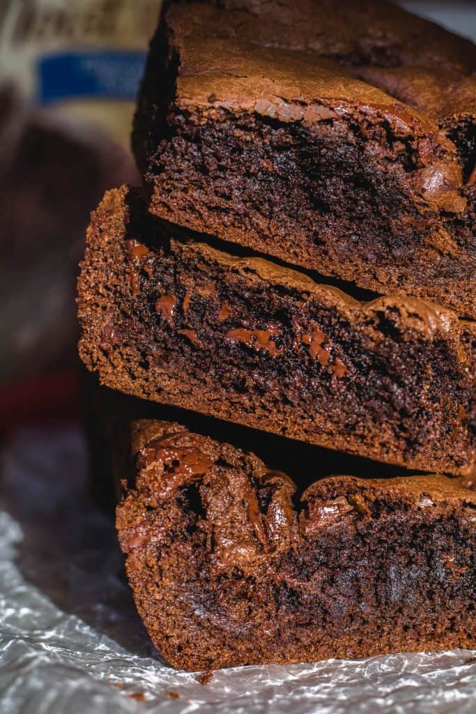 Close up stack of fudgy cake mix brownies showing melted chocolate pools and a dense chewy interior