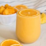 Mango orange smoothie with an orange slice on top