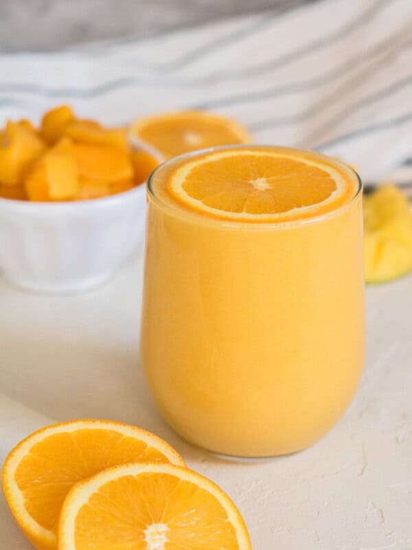 Mango orange smoothie with an orange slice on top