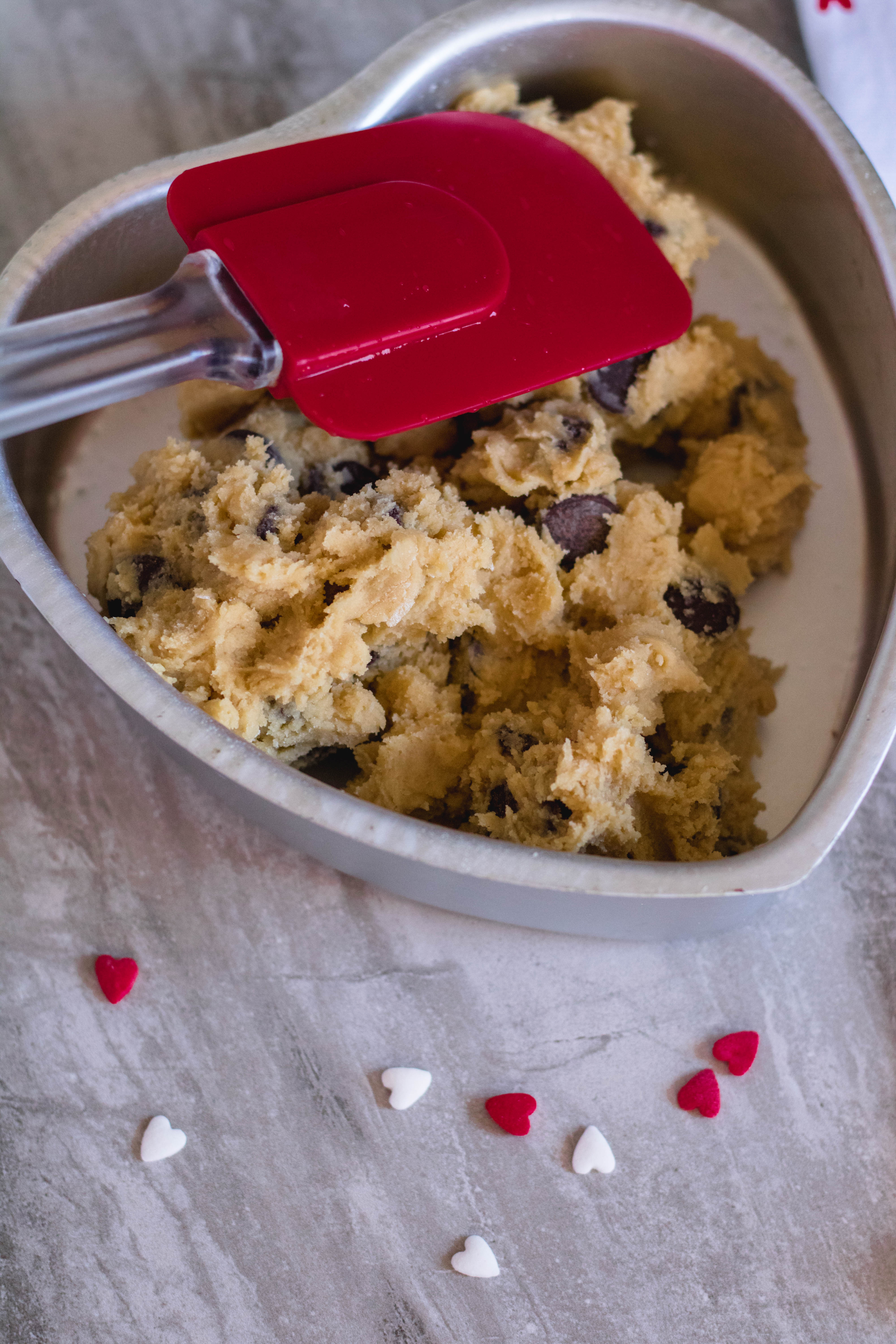 spread the cookie dough in the heart baking pan