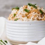 Lebanese rice pilaf with toasted vermicelli and parsley piled high in a ribbed white bowl.