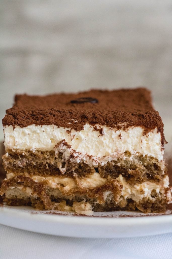 Slice of easy no-bake tiramisu with creamy mascarpone layers and cocoa topping