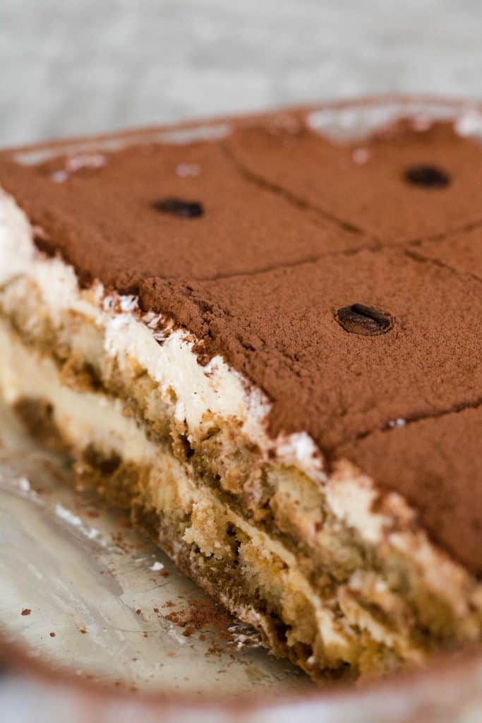 No-bake tiramisu cut into squares in a glass baking dish