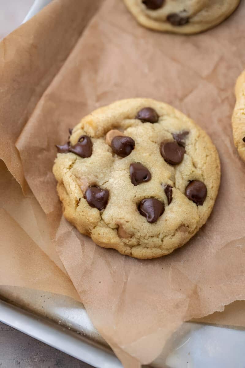 Just baked small batch chocolate chip cookie still slightly puffy on the hot sheet before it settles.