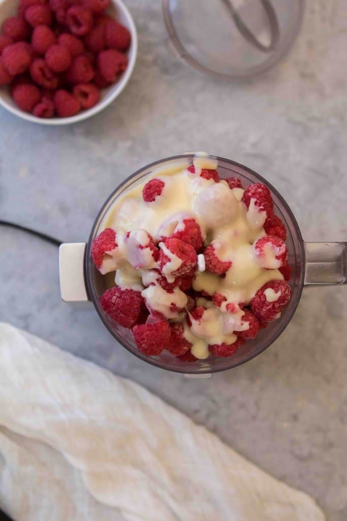 Adding the sweetened condensed milk to the raspberries