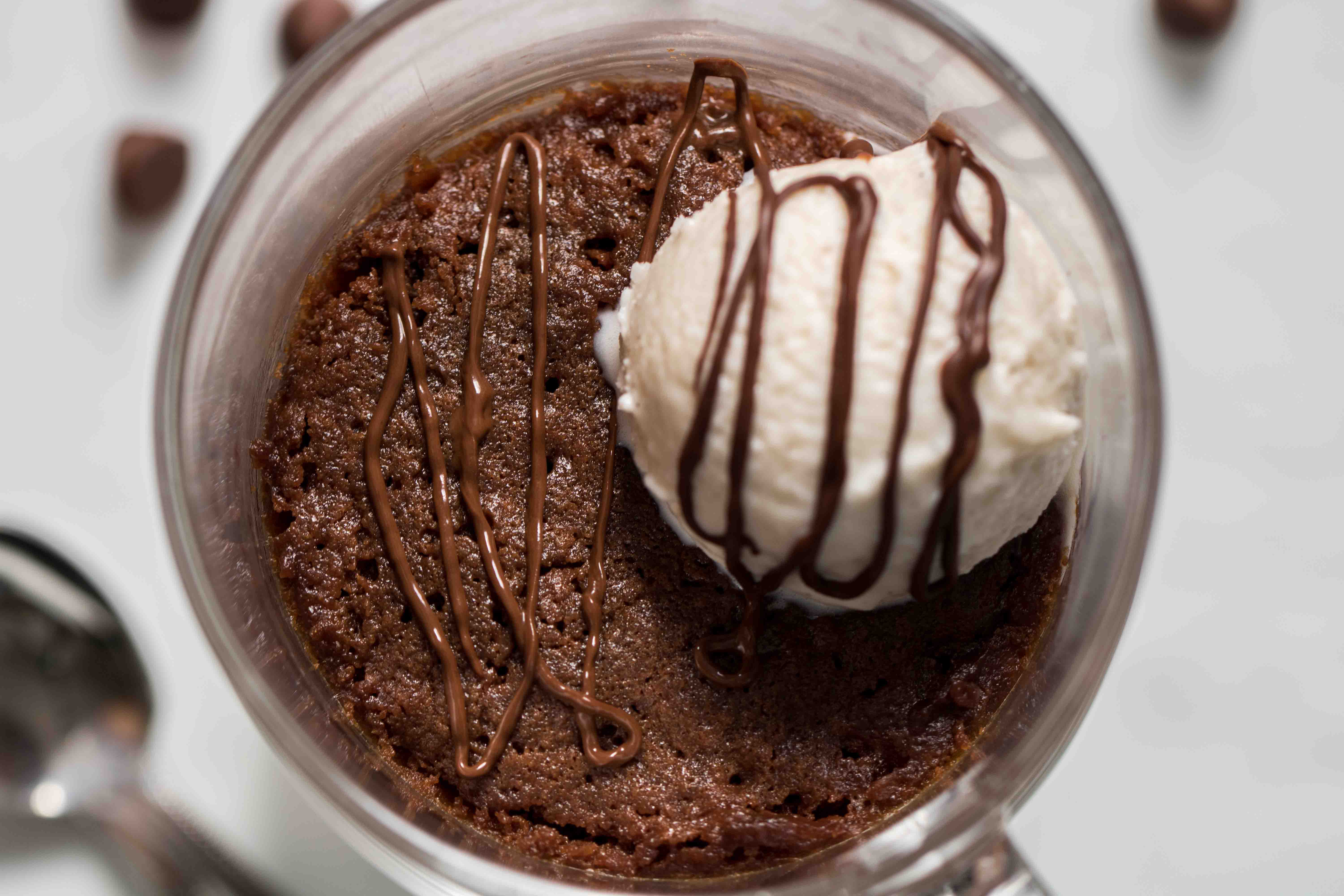 The top of the brownie in a mug recipe with a vanilla bean ice cream scoop