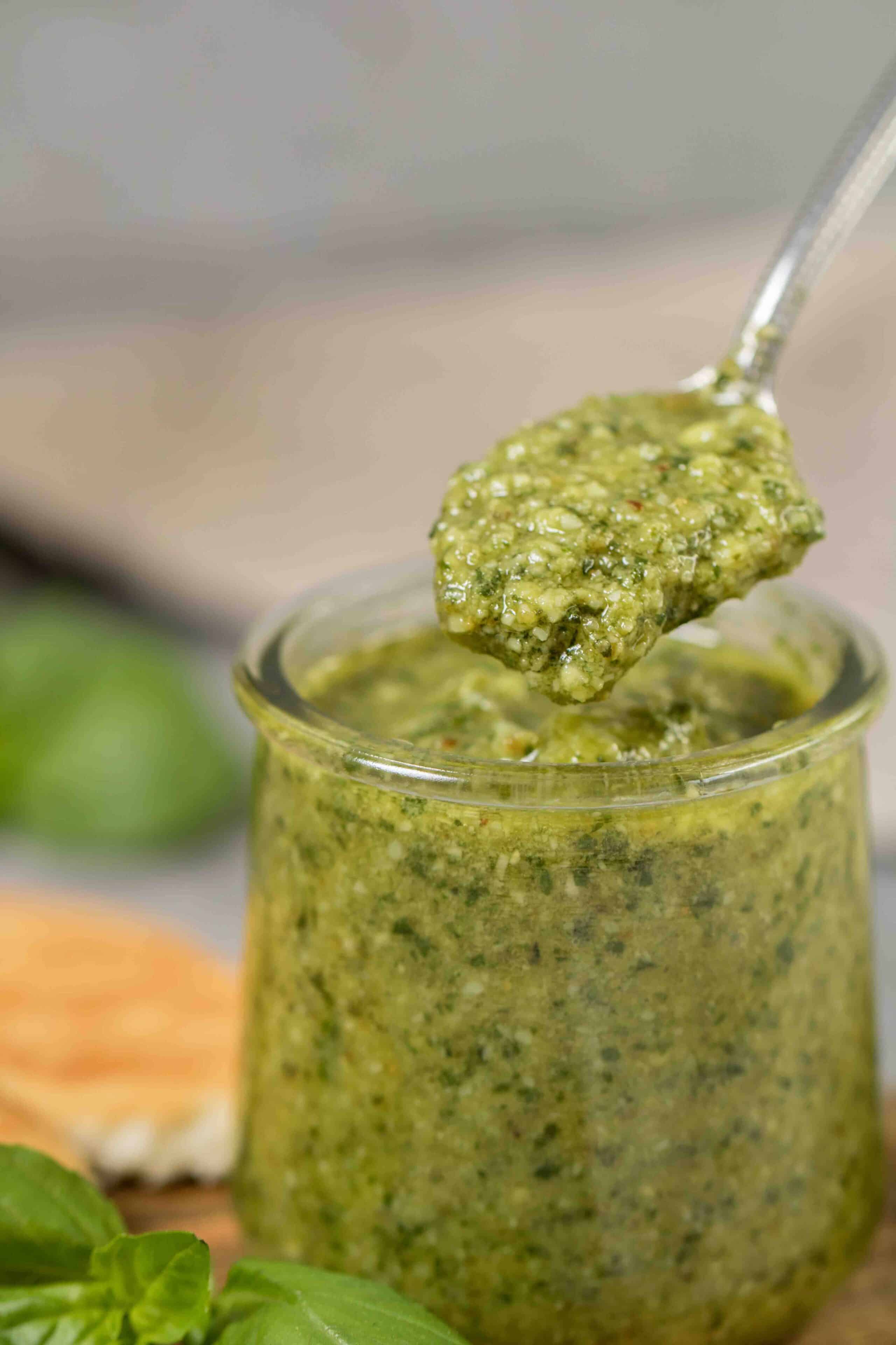 Spoon filled with creamy pesto sauce