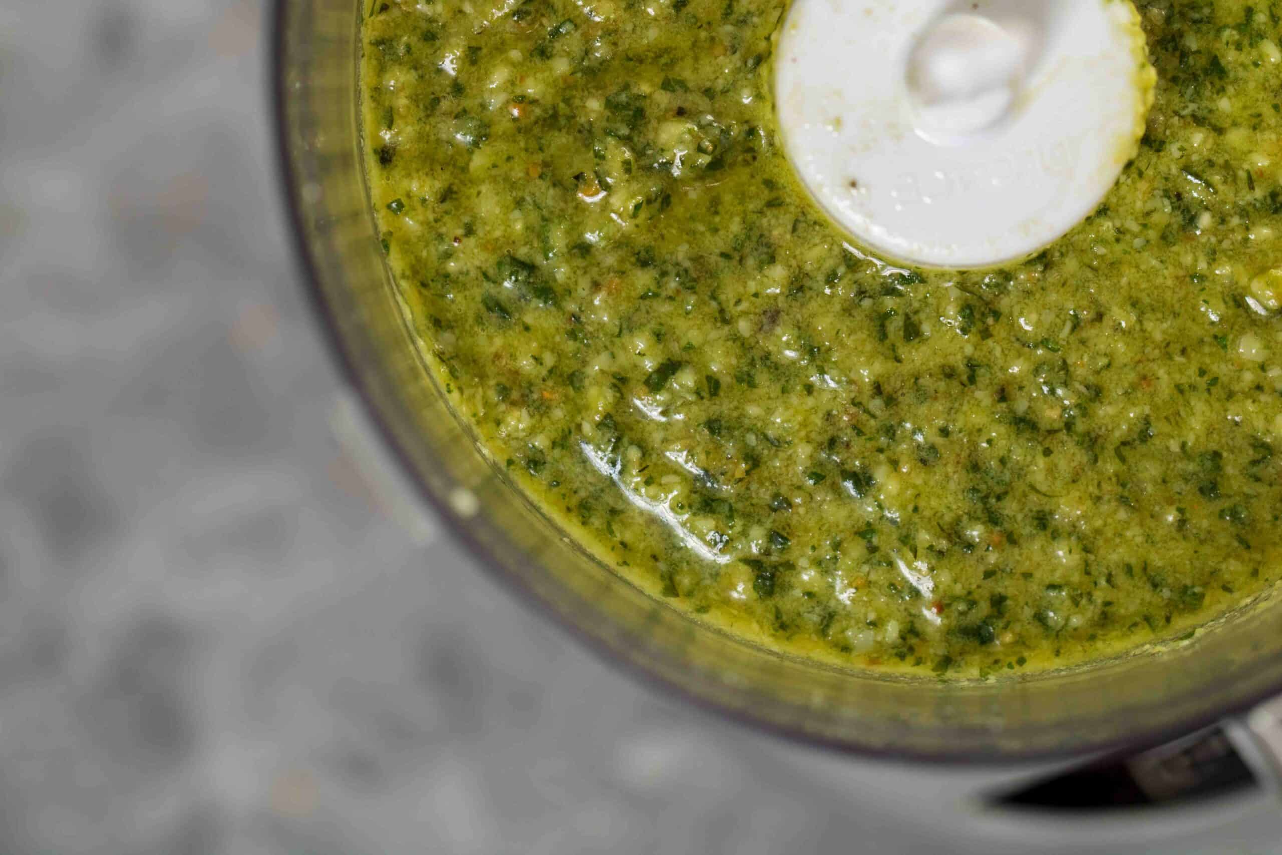 Overhead close up shot of texture of green pesto recipe