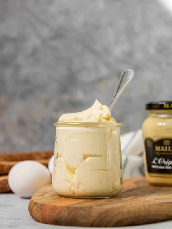 Homemade mayonnaise with eggs and bread in the background
