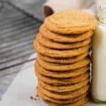 Soft and chewy brown sugar cookies stacked up against a bottle of milk