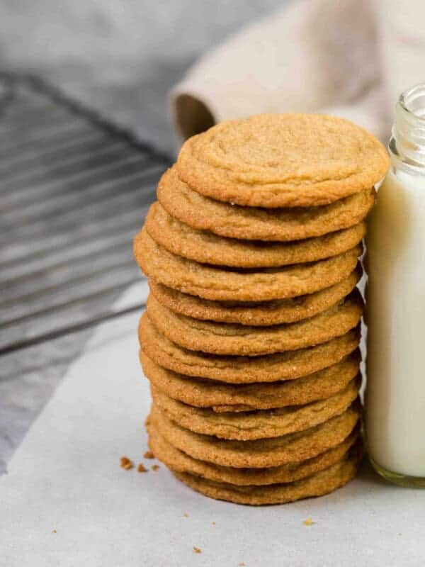 Soft and chewy brown sugar cookies stacked up against a bottle of milk