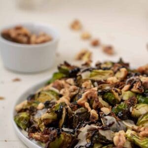 Air Fried Brussel Sprouts on a plate with balsamic glaze and nuts