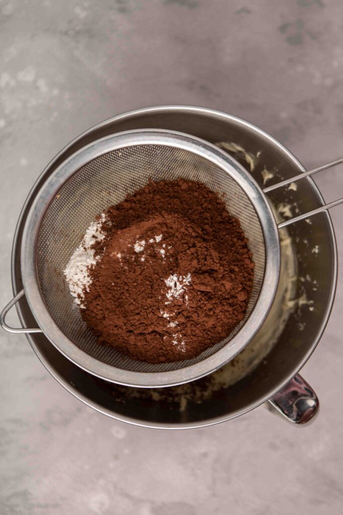 sifting cocoa powder and flour into brownies