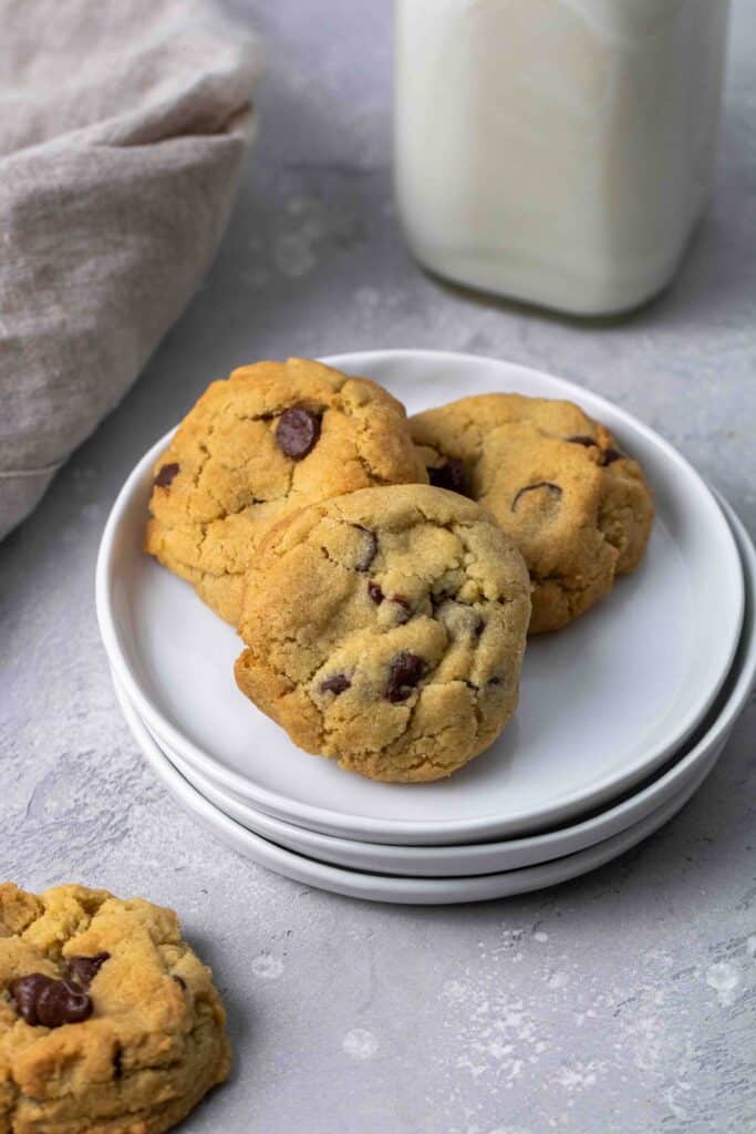 Stack of soft and chewy air fryer chocolate chip cookies on white plates