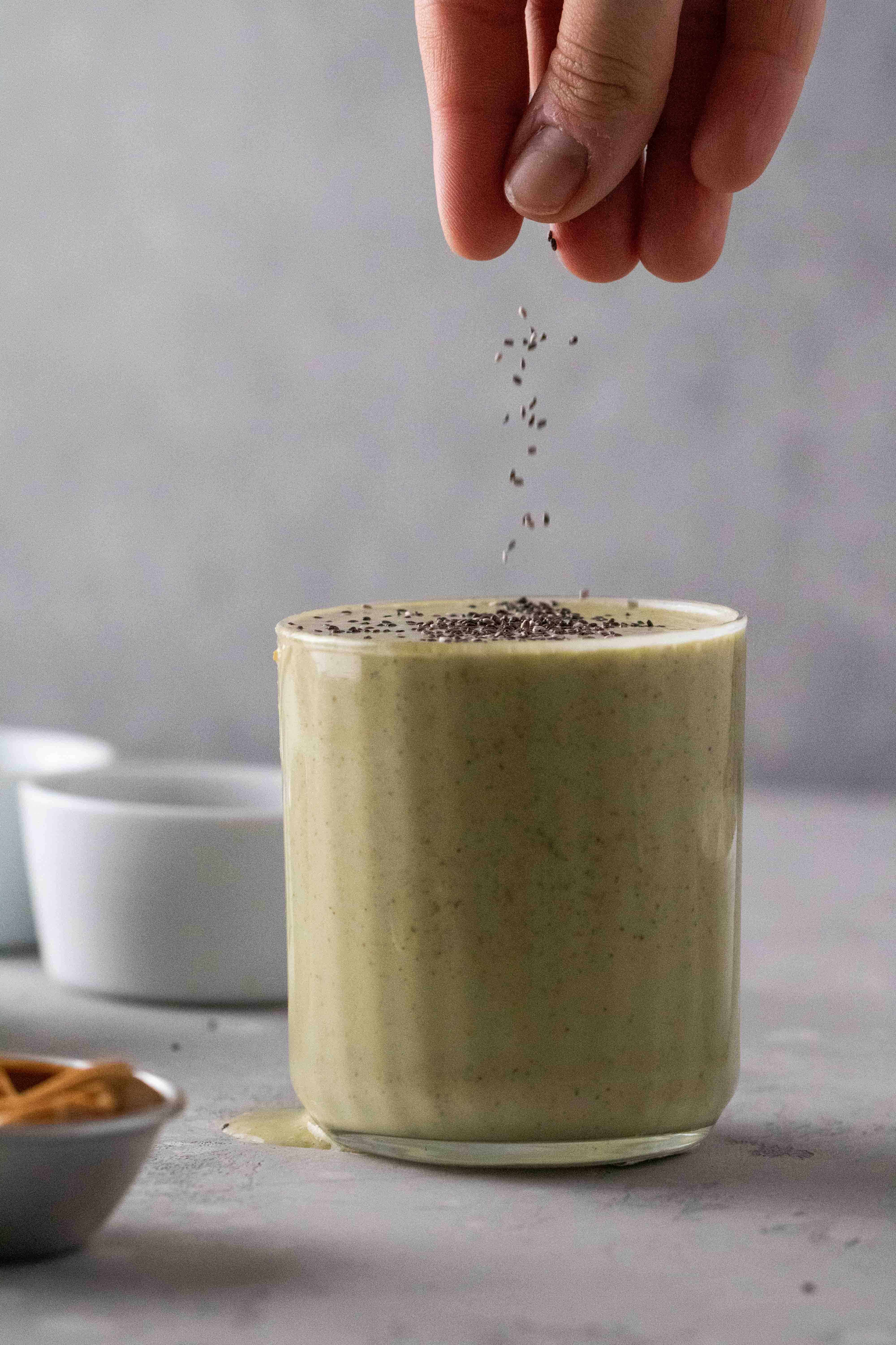 chia seeds falling on top of the matcha green smoothie recipe