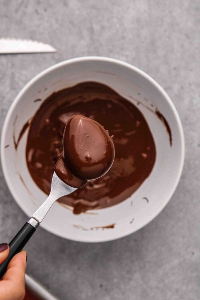Dipping the peanut butter eggs in melted chocolate
