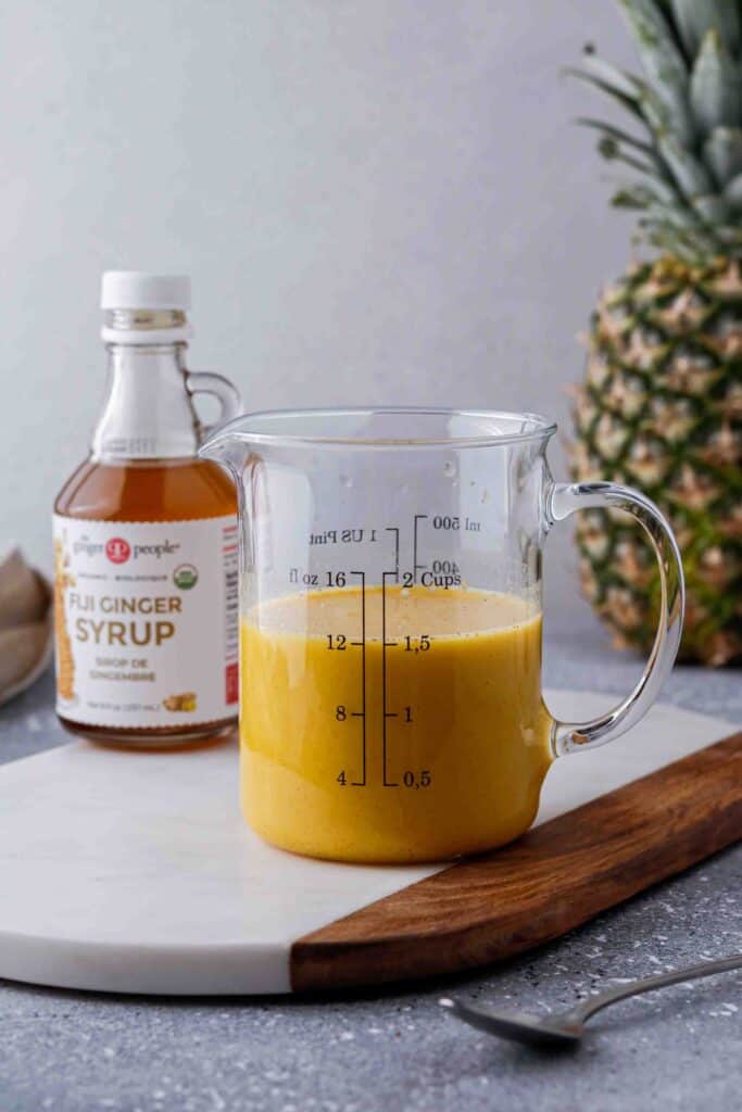 Iced golden Starbucks drink in a measuring cup