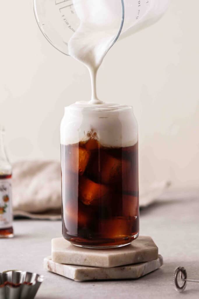 Top the cold brew coffee with vanilla sweet cream 