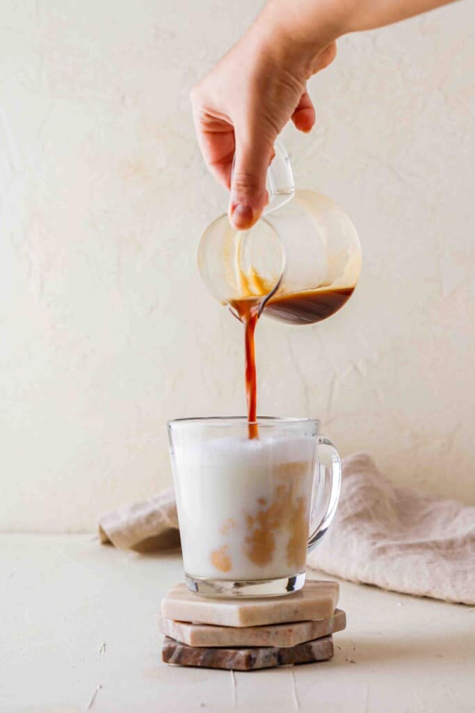 Pouring espresso in steamed milk