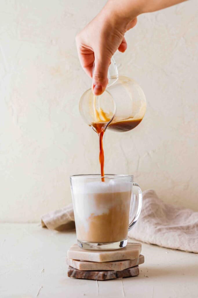 Pouring espresso in steamed milk