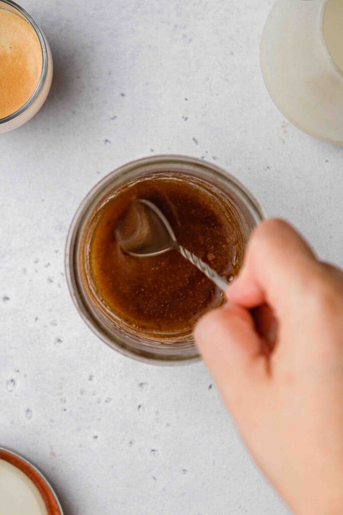 Spoon stirring brown sugar syrup