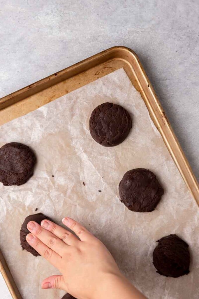 Hand flattening chocolate cookie dough