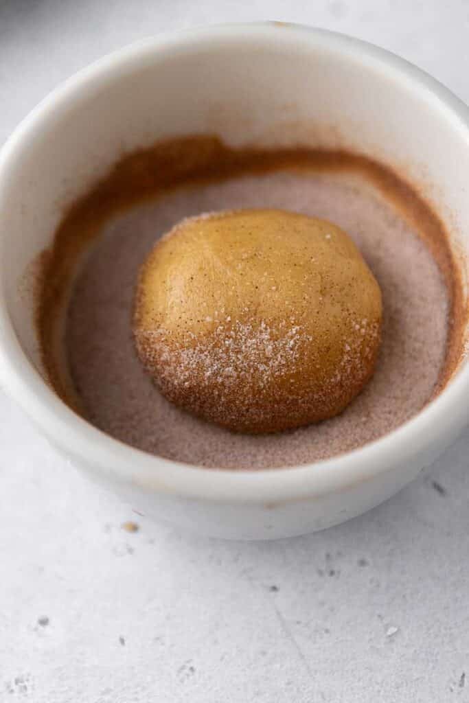 Cookie dough ball in cinnamon sugar mixture