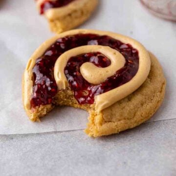 Peanut butter and jelly cookies with a bite taken out of it
