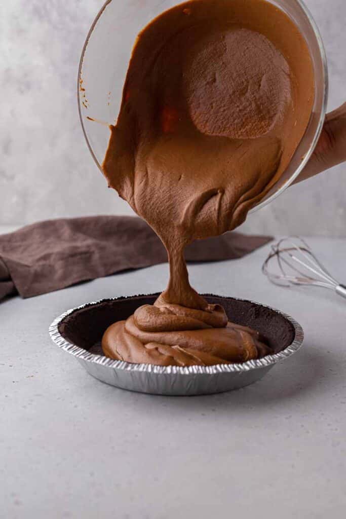 Pouring chocolate pie filling into oreo crust