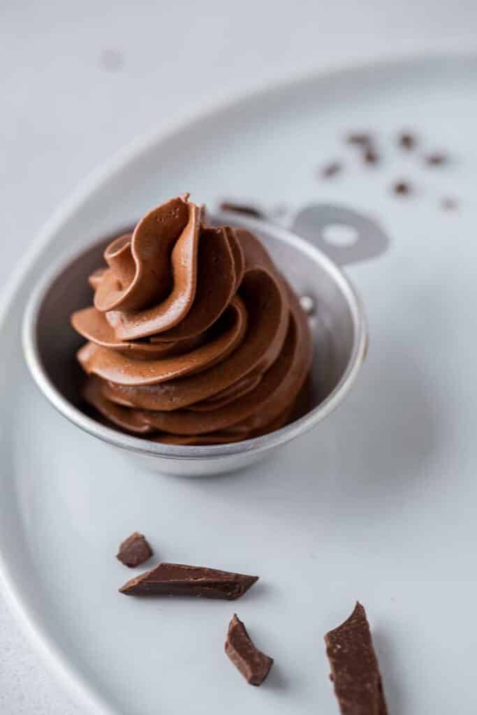 small batch chocolate Swiss meringue buttercream piped in measuring cup