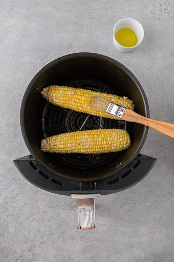 Brushing corn with oil