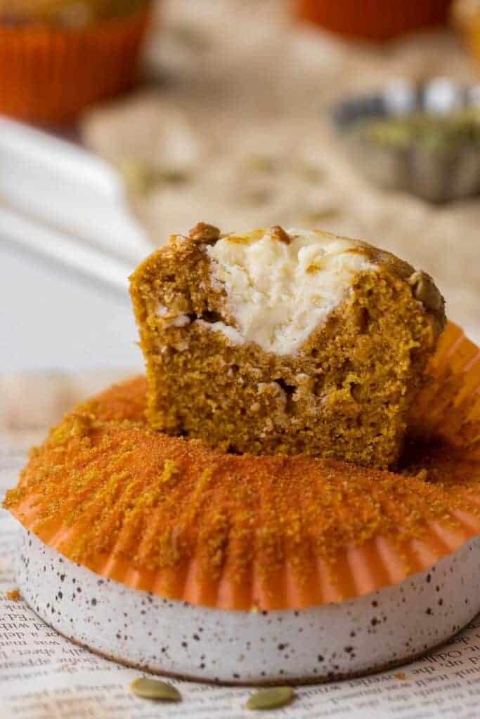 Starbucks pumpkin cream cheese muffin split open showing the thick white cream cheese center inside.
