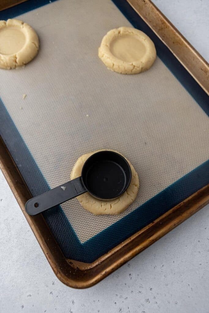 Pressing sugar cookies with a cup
