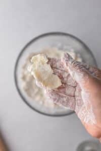 Hand holding floured butter