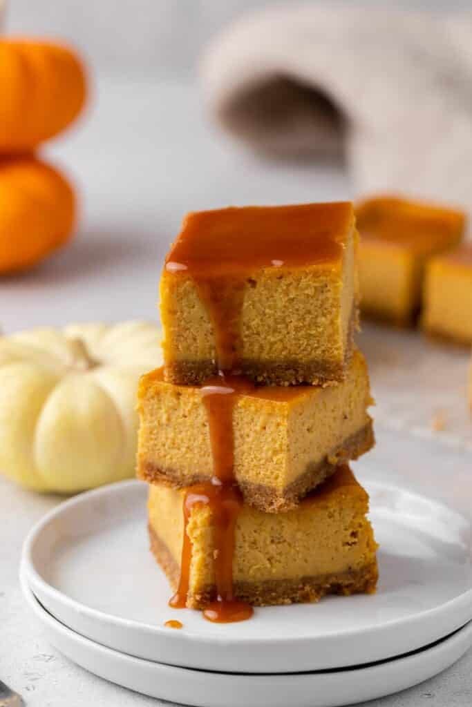 Stack of pumpkin cheesecake bars with caramel