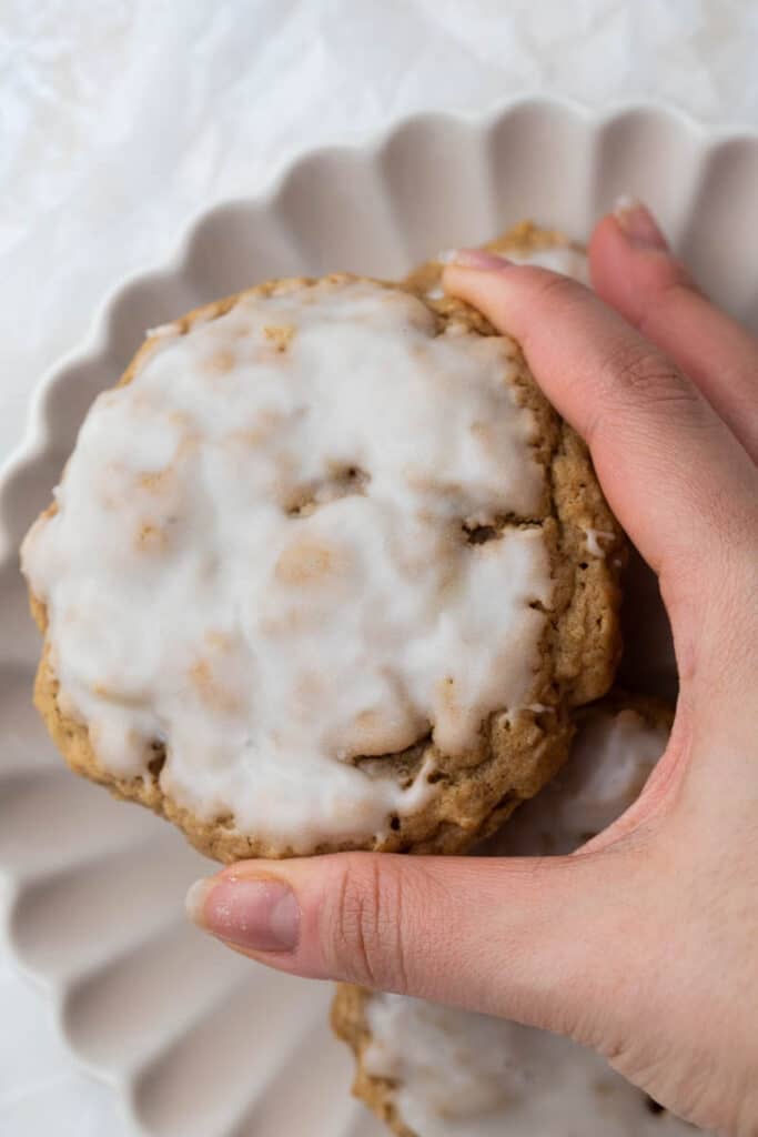 hand holding iced oatmeal cookies