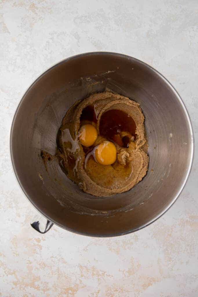Creamed butter and dark brown sugar in a mixing bowl with eggs, honey, and vanilla ready.