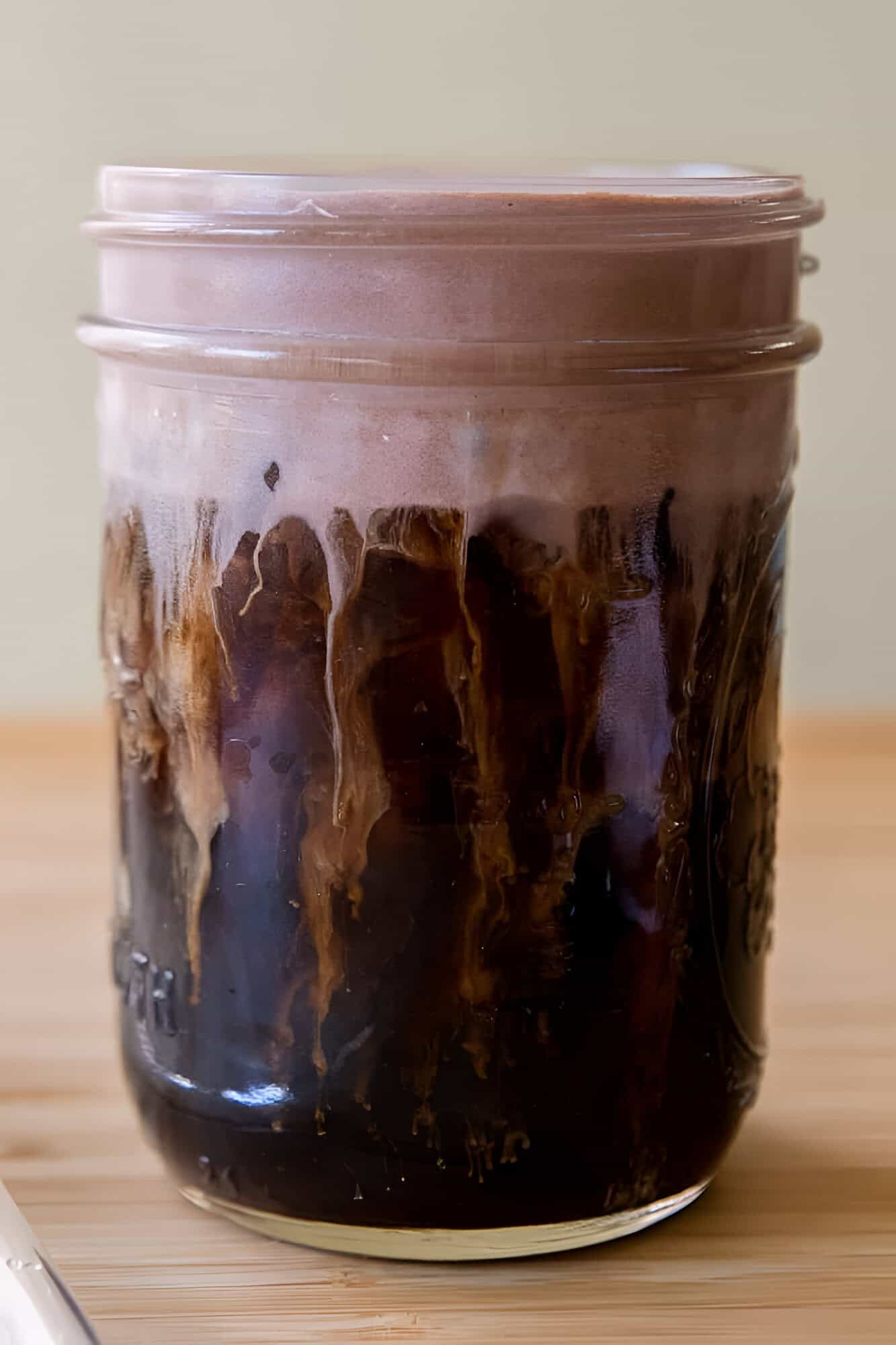 Tall glass of Starbucks chocolate cream cold brew with a thick layer of malted chocolate foam.