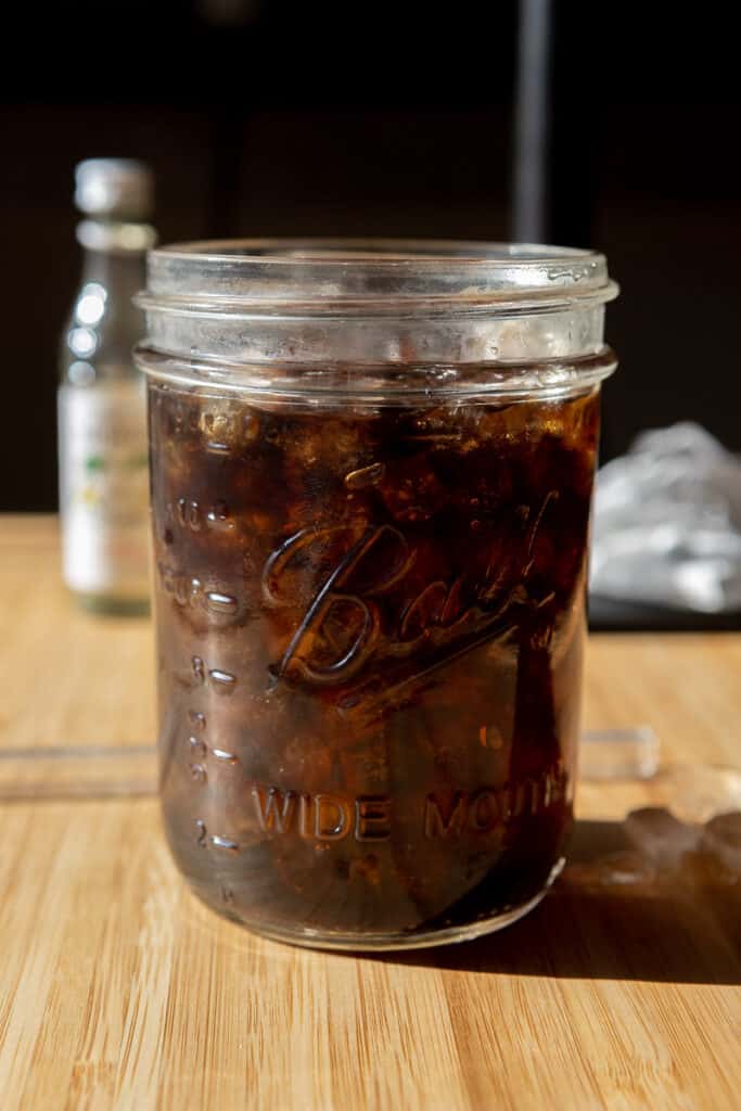 Cold brew poured over nugget ice in a tall glass with an inch of space left.