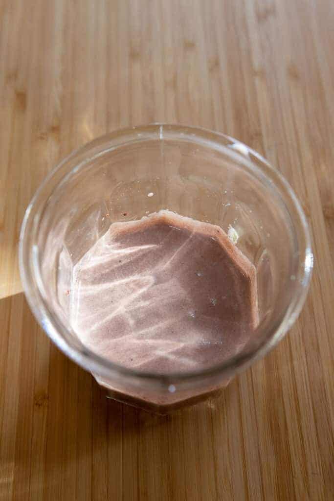 Chocolate cream mixture frothed in a glass cup until it has doubled in volume and thickened.