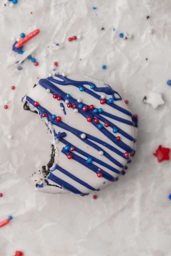 red white and blue chocolate covered Oreo with a bite taken out of it