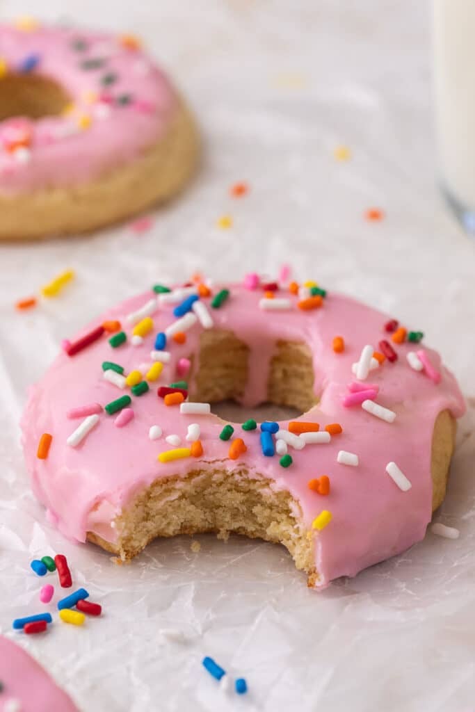 Crumbl pink donut cookie with a bite taken out of it 